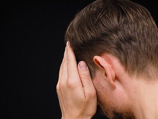 Image showing Male caucasian person covering face with one hand isolated towar