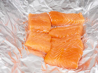 Image showing Closeup of unseasoned salmon pieces in aluminum foil