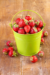 Image showing strawberry in a green metal bucket on wooden 