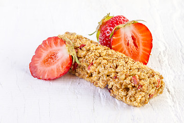 Image showing muesli bars with fresh strawberry on white wooden