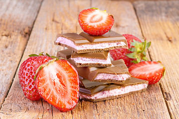 Image showing chocolate with strawberry cream on wooden
