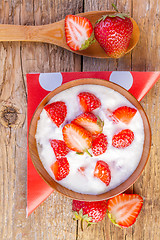 Image showing fresh organic greek yogurt with strawberries on wooden