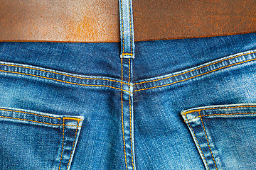 Image showing vintage blue denim with seams and leather belt,  part of 