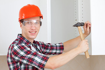 Image showing repairman in a helmet with a hammer