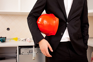 Image showing businessman holding red helmet