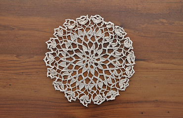 Image showing Lace doily on dark wood