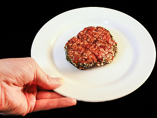Image showing Serving raw burger on white plate isolated on black