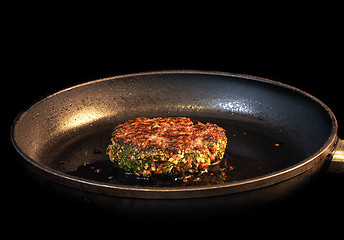 Image showing Frying seasoned hamburger in fry pan isolated on black