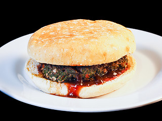 Image showing Closeup of juicy hamburger between buns with delicious red sauce