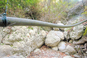 Image showing Plastic pipe hanging over the land like a snake