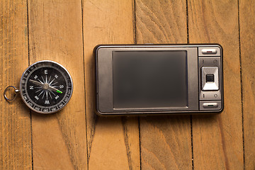 Image showing smartphone and compass on wooden background