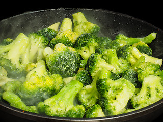 Image showing Thawing frozen green broccoli in a hot fry pan