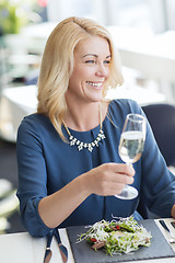 Image showing happy woman drinking champagne at restaurant