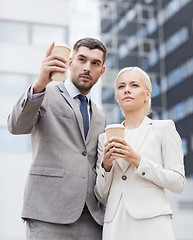 Image showing serious businessmen with paper cups outdoors