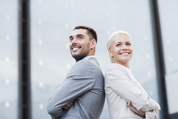 Image showing smiling businessmen standing over office building