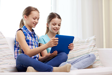 Image showing happy girls with tablet pc sitting on sofa at home