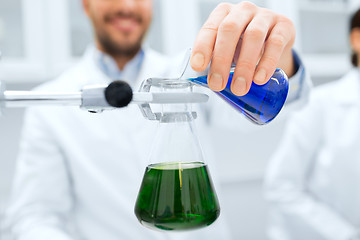 Image showing close up of scientist filling test tubes in lab