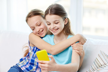 Image showing happy girls with smartphone taking selfie at home