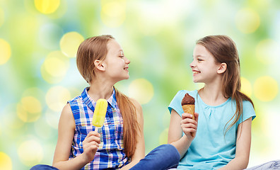 Image showing happy little girls eating ice-cream over green