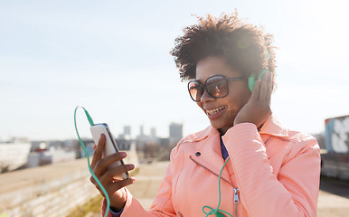 Image showing happy young woman with smartphone and headphones