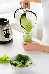Image showing close up of woman with blender jar and green shake