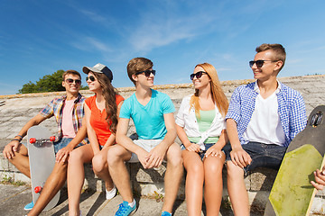 Image showing group of smiling friends sitting on city street