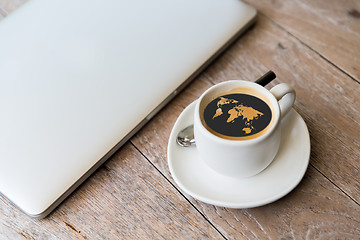 Image showing close up of laptop and coffee cup with world map