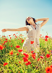 Image showing smiling young woman on poppy field