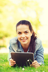 Image showing smiling young girl tablet pc lying on grass