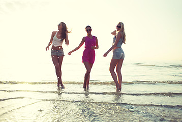 Image showing happy female friends dancing on beach