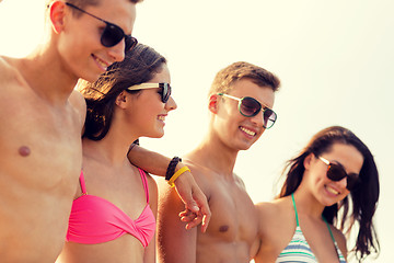 Image showing smiling friends in sunglasses on summer beach