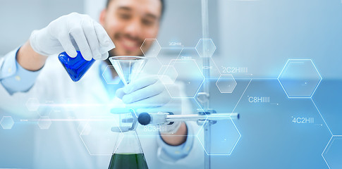 Image showing close up of scientist with test tubes and funnel