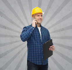 Image showing smiling male builder in helmet with clipboard