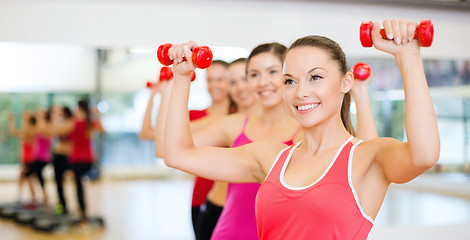 Image showing group of smiling people working out with dumbbells