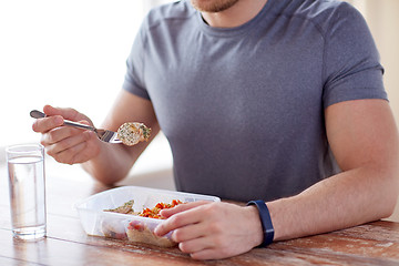 Image showing close up of man with fork and water eating food