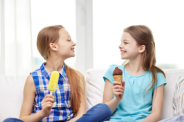 Image showing happy little girls eating ice-cream at home