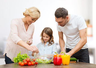 Image showing happy family cooking vegetable salad for dinner