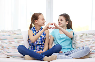 Image showing happy little girls showing heart shape hand sign