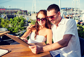 Image showing smiling couple with menu at cafe