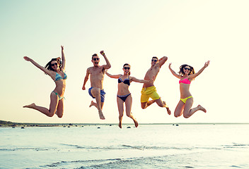 Image showing smiling friends in sunglasses on summer beach