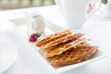 Image showing close up of waffles on plate at breakfast table 