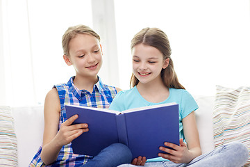 Image showing two happy girls reading book at home