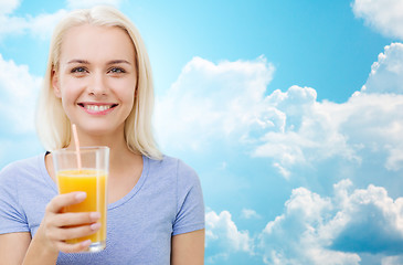 Image showing smiling woman drinking orange juice