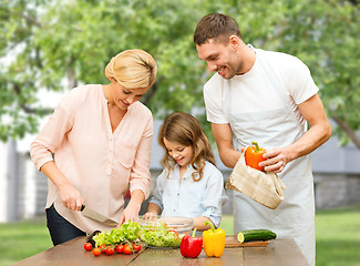 Image showing happy family cooking vegetable salad for dinner