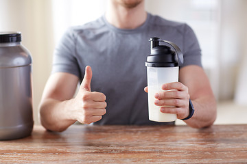 Image showing man with protein shake bottle showing thumbs up