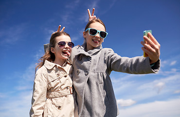 Image showing happy girls with smartphone taking selfie outdoors