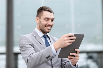 Image showing smiling businessman with tablet pc outdoors