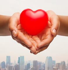 Image showing close up of female hands holding small red heart