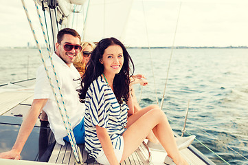 Image showing smiling friends sitting on yacht deck