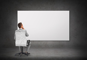 Image showing businessman in office chair over white board